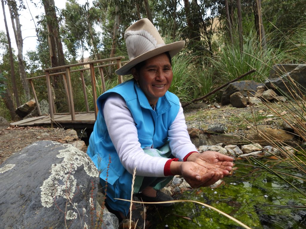 Delia Rodríguez muestra el agua tratada a la salida de la planta piloto de biorremediación, que busca mejorar su calidad para riego. La experiencia ya se viene implementando en el sector de Canrey Chico gracias al proyecto Cuencas Vivas. Foto: Profonanpe
