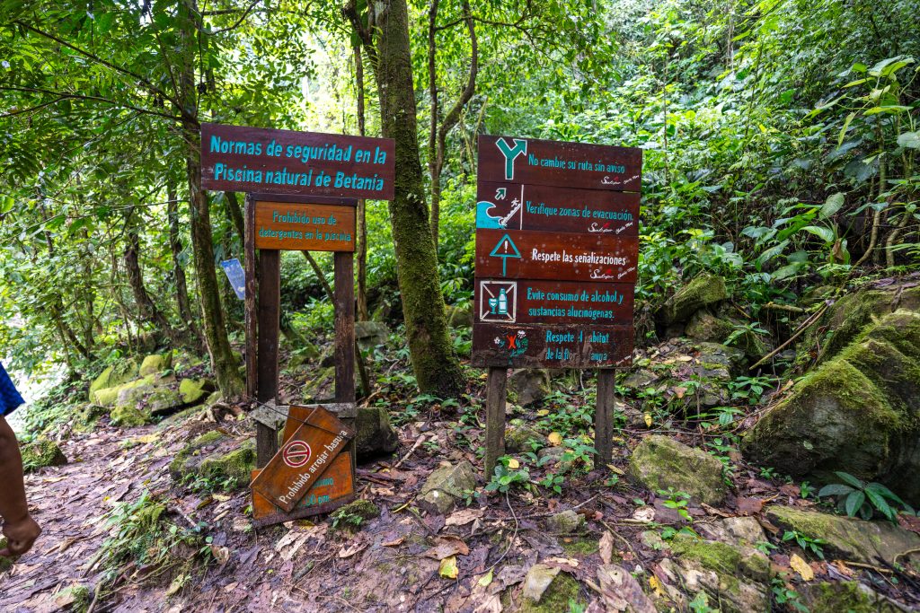 Señalética ubicada en el acceso a la piscina natural de Betania orienta a las y los visitantes sobre las medidas de seguridad y el cuidado del espacio durante su recorrido.